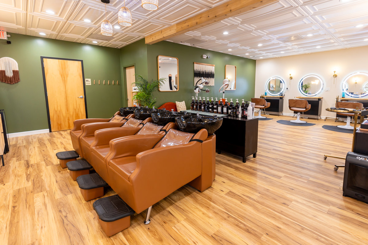Leather chairs and sage green entry wall in the Solace Salon lounge