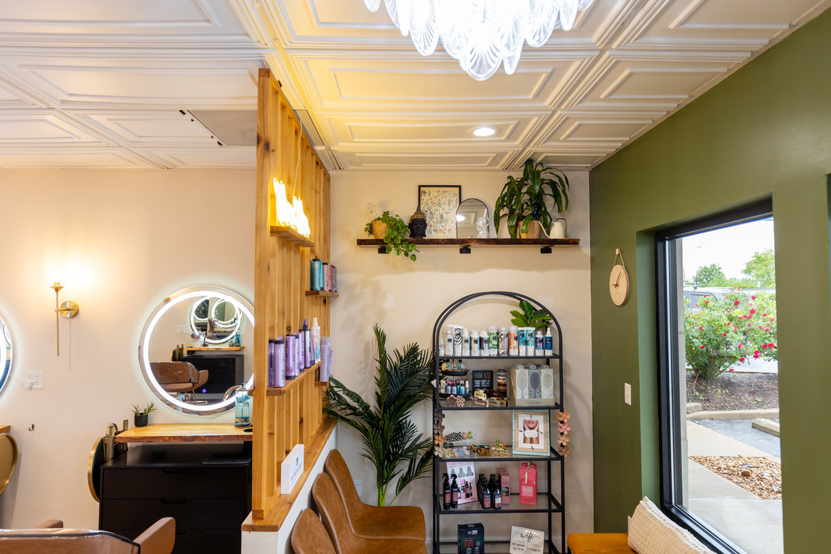 Product shelves and plants in the hallway at Solace Salon